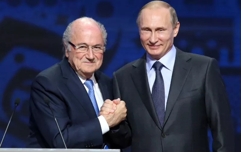 Outgoing FIFA president Sepp Blatter shakes hands with Russian President Vladimir Putin (R) ahead of the preliminary draw for the 2018 World Cup qualifiers at the Konstantin Palace in Saint Petersburg on July 25, 2015.  AFP PHOTO / KIRILL KUDRYAVTSEV
