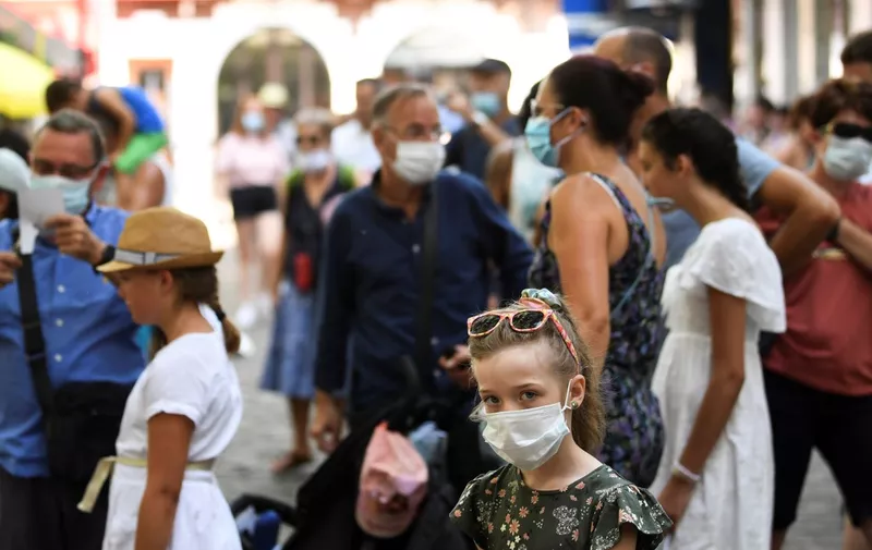 A child wearing a protective facemask visits the Montmartre neighbourhood, in Paris, on August 11, 2020 as the mayor decided to make the mask compulsory in certain areas of the city to fight against the rising of new infected cases of COVID-19 (the novel coronavirus). (Photo by ALAIN JOCARD / AFP)