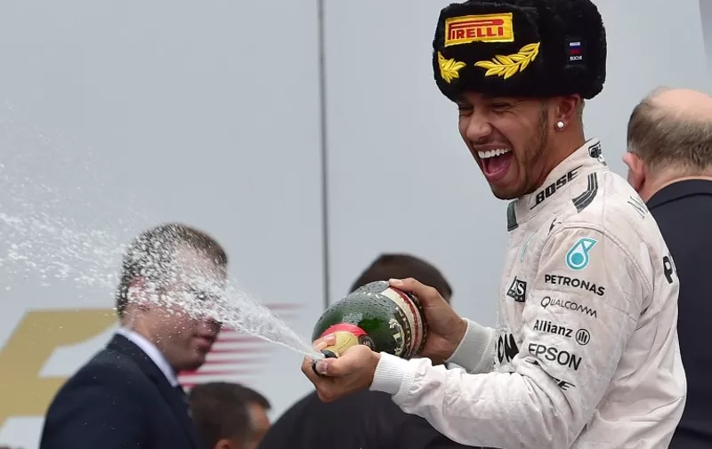 Mercedes AMG Petronas F1 Team's British driver Lewis Hamilton pours champagne as he celebrates his victory after the Russian Formula One Grand Prix at the Sochi Autodrom circuit on October 11, 2015. AFP PHOTO / ANDREJ ISAKOVIC