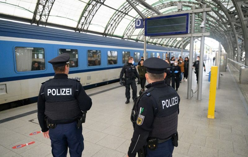 PRODUCTION - 10 October 2022, Saxony, Dresden: Federal police officers lead refugees arriving from Syria to the registration area at the main train station. Photo: Robert Michael/dpa (Photo by ROBERT MICHAEL / DPA / dpa Picture-Alliance via AFP)