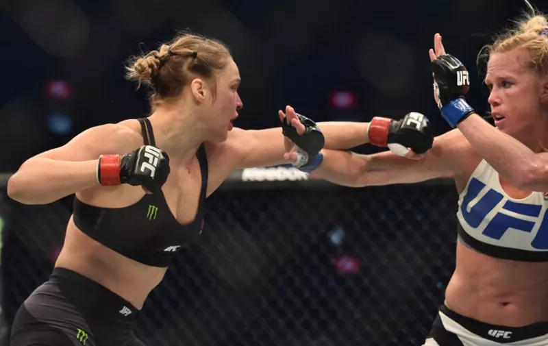 Ronda Rousey of the US (L) lines up compatriot Holly Holm (R) during the UFC title fight in Melbourne on November 15, 2015.   RESTRICTED TO EDITORIAL USE NO ADVERTISING USE NO PROMOTIONAL USE NO MERCHANDISING USE.  AFP PHOTO/Paul CROCK / AFP PHOTO / PAUL CROCK