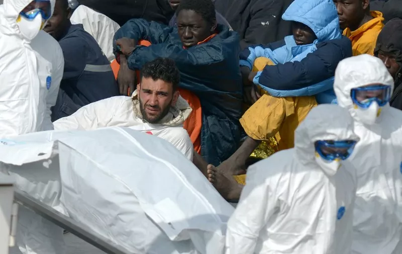 This picture taken on April 20, 2015 shows a man now identified as Tunisian national Mohammed Ali Malek (C), one of the survivors and understood to be the captain of the boat that overturned off the coasts of Libya, sits on board the Italian Coast Guard vessel Bruno Gregoretti at Boiler Wharf, Senglea in Malta. [&hellip;]