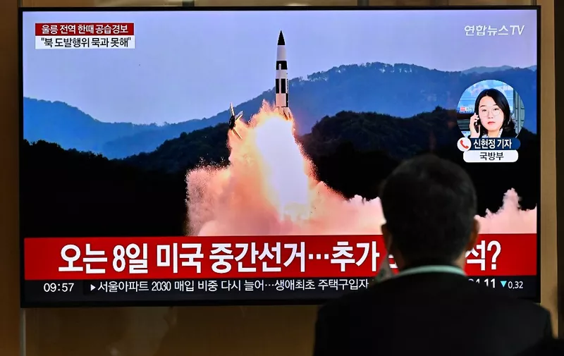 A man watches a television screen showing a news broadcast with file footage of a North Korean missile test, at a railway station in Seoul on November 2, 2022. - South Korea on November 2 told residents on the island of Ulleungdo off its east coast to evacuate to bunkers after North Korea fired three short range ballistic missiles. (Photo by JUNG YEON-JE / AFP)