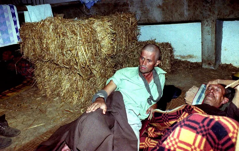 Two Bosnian prisoners lay in the makeshift infirmary of the Serbian internment camp for Bosnians in Manjaca, 40 km from Banja Luka, 14 August 1992 . Some 3,500 people gathered by Serbian nationalists in "ethnic cleansing" operations are held in this camp. (Photo by ANDRE DURAND / AFP)