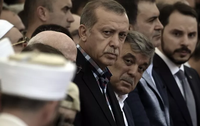 EDITORS NOTE: Graphic content / Turkish President Recep Tayyip Erdogan (C) and former Turkish president Abdullah Gul (C-R) attend the funeral of a victim of the coup attempt in Istanbul on July 17, 2016.
Turkish President Recep Tayyip Erdogan vowed on July 17 to purge the "virus" within state bodies, during a speech at the funeral of victims killed during the coup bid he blames on his enemy Fethullah Gulen. / AFP PHOTO / ARIS MESSINIS