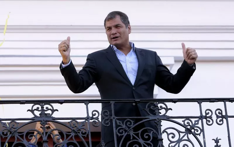 Ecuadorean President Rafael Correa waves to supporters, from the balcony of the presidential palace during a demonstration in Quito on April 7, 2016.
Correa's supporters reacted to opposition protests against controversial tax increases pushed by the president. / AFP PHOTO / JUAN CEVALLOS