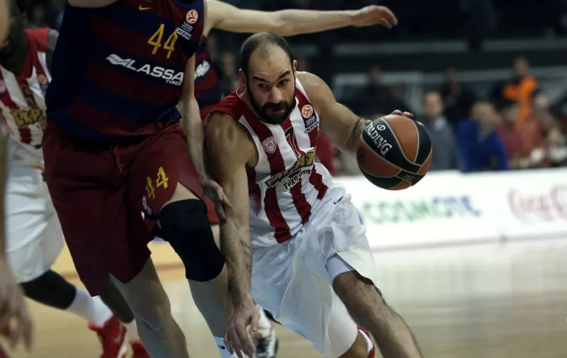 Olympiacos Piraeus' Vassilis Spanoulis (R) vies with Barcelona's Ante Tomic (L) during the Euroleague Top 16 group F basketball match between Olympiacos Piraeus and Barcelona at the Peace and Friendship stadium in the Piraeus district of Athens on December 29, 2015. / AFP / ANGELOS TZORTZINIS