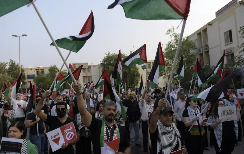 Protesters wave Palestinian flags during a solidarity sit-in with the Gaza Strip, in Manama on November 17, 2023, amid ongoing battles between Israel and Hamas militants. (Photo by Mazen Mahdi / AFP)