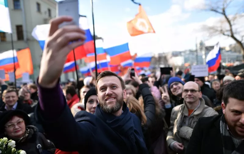 Russian opposition leader and anti-corruption blogger Alexei Navalny takes a selfie picture as he attends a memorial march marking the one-year anniversary of the assassination of Russian politician Boris Nemtsov in central Moscow, on February 27, 2016. Nemtsov, a former deputy prime minister in the government of Boris Yeltsin, was gunned down shortly before midnight on February 27, 2015, while walking across a bridge a short distance from the Kremlin with his Ukrainian model girlfriend. AFP PHOTO / KIRILL KUDRYAVTSEV / AFP PHOTO / KIRILL KUDRYAVTSEV