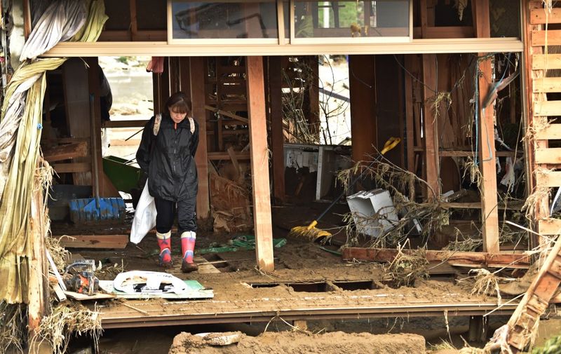 A resident stands inside her flood-damaged home in Nagano on October 15, 2019, after Typhoon Hagibis hit Japan on October 12 unleashing high winds, torrential rain and triggered landslides and catastrophic flooding. - The death toll from the disaster has risen steadily, and the national broadcaster early on October 15 said 58 people had been killed, according to authorities, while more than a dozen were still missing. (Photo by Kazuhiro NOGI / AFP)
