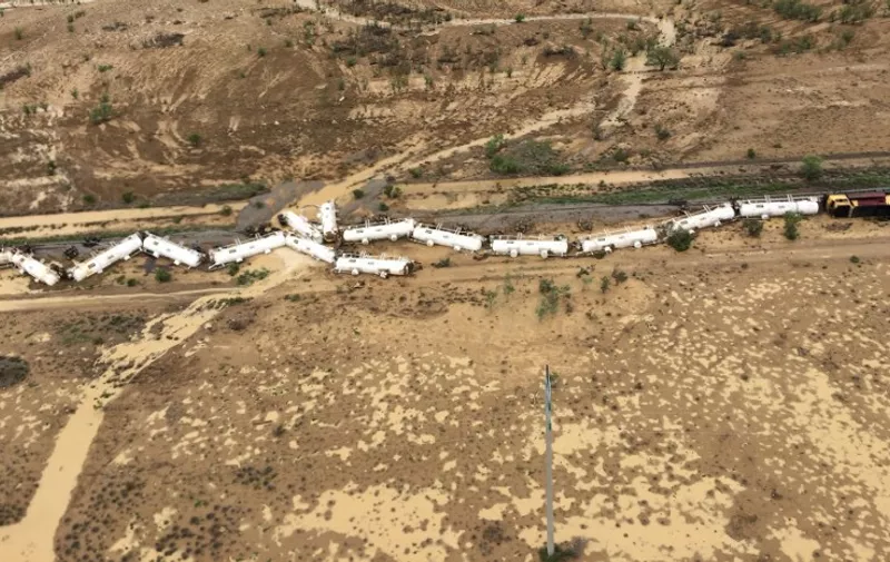 This handout photo released on December 28, 2015 by Queensland Rail shows a derailed freight train carrying approximately 200,000 litres of sulphuric acid east of Julia Creek in north-west Queensland. The authorities have declared an emergency under the Public Safety Preservation Act and have  placed a two-kilometre exclusion zone around the crash site after the accident. AFP PHOTO / QUEENSLAND RAIL  --EDITORS NOTE ----RESTRICTED TO EDITORIAL USE MANDATORY CREDIT " AFP PHOTO / QUEENSLAND RAIL" NO MARKETING NO ADVERTISING CAMPAIGNS - DISTRIBUTED AS A SERVICE TO CLIENTS - NO ARCHIVES / AFP / QUEENSLAND RAIL / QUEENSLAND RAIL