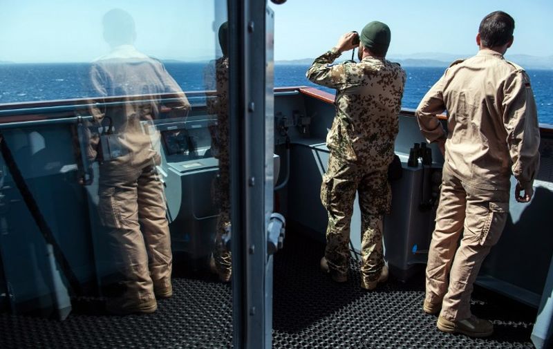 A member of the German army serving on the German navy support ship Bonn looks through binoculars in the Aegean Sea, off the Turkish coast on April 20, 2016. The Bonn is part of a NATO naval presence in the Aegean Sea meant to observe and monitor illegal naval movement between Turkey and Greece. Photo: JOHN MACDOUGALL/dpa