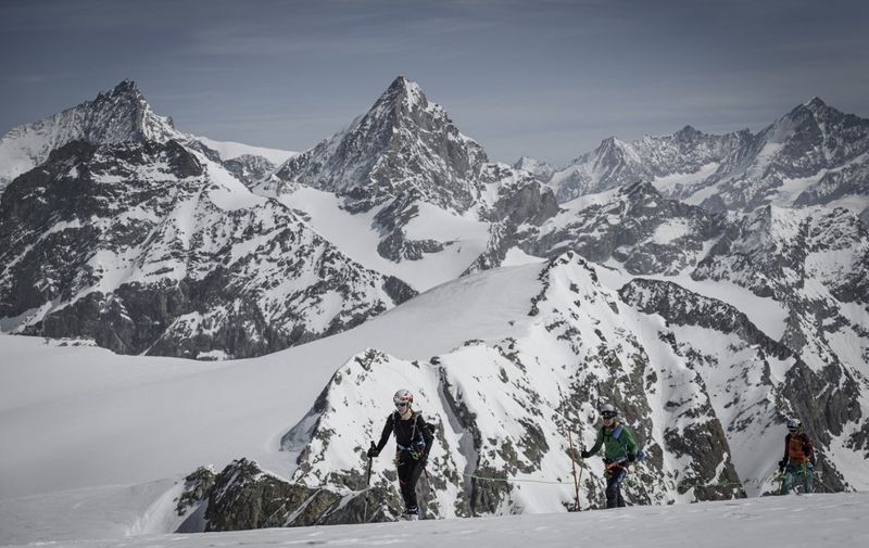 A photograph taken on April 14, 2022 shows ski mountaineers climbing the Tete Blanche high altitude pass between Zermatt and Arolla, surrounded by Swiss Alps. A major search operation is underway in the Swiss Alps to find six ski hikers missing since March 9, 2024 but the very bad weather conditions makes the emercency response very difficult, police announced. The group left Zermatt and has been missing in the Tete Blanche area. (Photo by Gabriel Monnet / AFP)