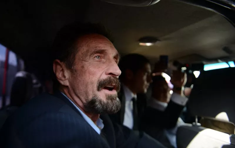 US anti-virus software pioneer John McAfee gestures as he arrives at the Aurora international airport in Guatemala City on December 12, 2012. McAfee escaped immediate deportation to Belize on Wednesday as Guatemala decided to expel the American back to the United States instead.  McAfee, who entered Guatemala illegally after more than three weeks on the run, is wanted in Belize for questioning over his neighbor's murder last month.  AFP PHOTO/JOHAN ORDONEZ (Photo by JOHAN ORDONEZ / AFP)