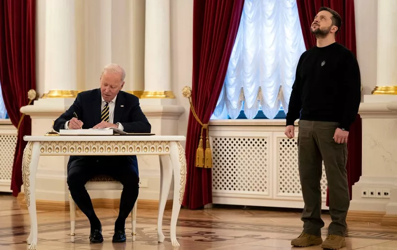 President Joe Biden (L) signs the guest book during a meeting with Ukrainian President Volodymyr Zelensky at the Mariinsky Palace in Kyiv on February 20, 2023. US President Joe Biden promised increased arms deliveries for Ukraine during a surprise visit to Kyiv on February 20, 2023, in which he also vowed Washington's "unflagging commitment" in defending Ukraine's territorial integrity. (Photo by Evan Vucci / POOL / AFP)
