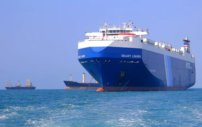 A picture taken during an organised tour by Yemen's Huthi rebels on November 22, 2023 shows the Galaxy Leader cargo ship (R), seized by Huthi fighters two days earlier, approaching the port in the Red Sea off Yemen's province of Hodeida. The Bahamas-flagged, British-owned Galaxy Leader, operated by a Japanese firm but having links to an Israeli businessman, was headed from Turkey to India when it was seized and re-routed to Hodeida November 19, according to maritime security company Ambrey. The Huthis said the capture was in retaliation for Israel's war against Hamas, sparked by the October 7 attack by the Palestinian militants who killed 1,200 people and took around 240 hostages, according to Israeli officials. (Photo by AFP)