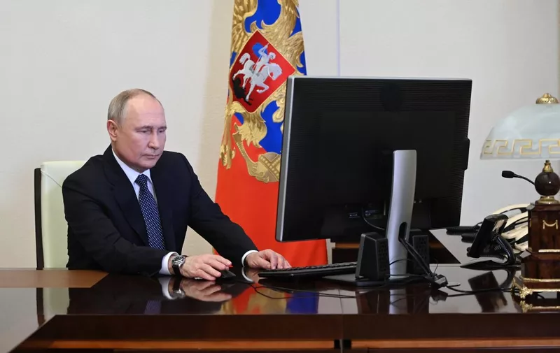 In this pool photograph distributed by Russia's state agency Sputnik, Russian President Vladimir Putin votes online in the presidential election at the Novo-Ogaryovo state residence, outside Moscow, on March 15, 2024. (Photo by Pavel Byrkin / POOL / AFP)