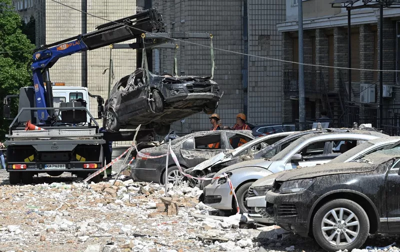 Damaged cars are covered with dust and rubble at the bottom of a partially destroyed building after an overnight drone attack in Kyiv on May 30, 2023. Ukraine on May 30, 2023 said it had downed 29 out of 31 drones, mainly over Kyiv and its region in the latest Russian barrage - the third on the capital in 24 hours. (Photo by Genya SAVILOV / AFP)