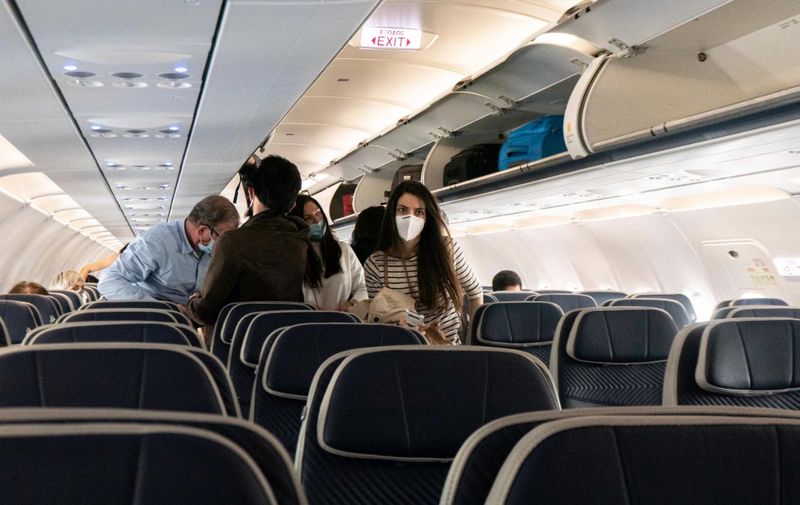 Passengers inside the cabin of an airplane are disembarking an Aegean Airlines Airbus A320neo after a domestic flight from Athens while they're seen wearing protective face masks due to Covid-19 Coronavirus pandemic at Thessaloniki International Airport Makedonia SKG LGTS. Greece spotted the Delta mutation in June and nowadays this Covid variant is the majority of the cases, the country imposed new measures and local lockdowns trying to boost the vaccination program as well. Thessaloniki airport is owned by the Greek Government but is operated with long term lease by Fraport Greece, subsidiary of Fraport Aktiengesellschaft AG. Thessaloniki, Greece on July 2021 (Photo by Nicolas Economou/NurPhoto) (Photo by Nicolas Economou / NurPhoto / NurPhoto via AFP)