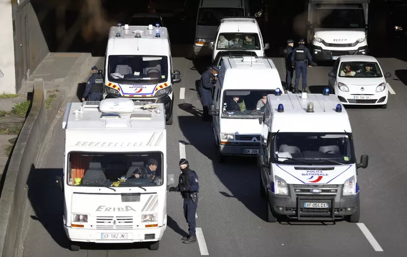 Police officers control vehicles at Porte de Saint-Cloud, western Paris, on February 12, 2022, as convoys of protesters from the "Convoi des Libertes" arrive in the French capital. - Thousands of protesters in convoys, inspired by Canadian truckers paralysing border traffic with the US, were heading to Paris from across France on February 11, with some hoping to blockade the capital in opposition to Covid-19 restrictions despite police warnings to back off. The protesters include many anti-Covid vaccination activists, but also people protesting against fast-rising energy prices that they say are making it impossible for low-income families to make ends meet. (Photo by Sameer Al-DOUMY / AFP)