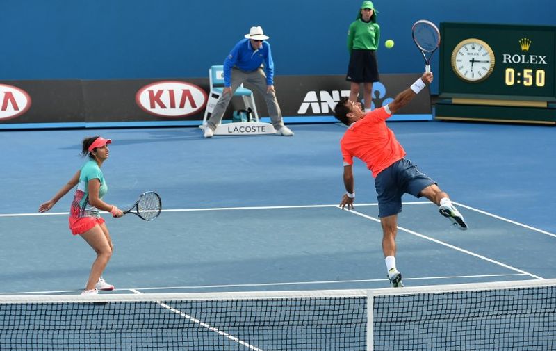 India's Sania Mirza (L) looks on as partner Croatia's Ivan Dodig plays a backhand return during their mixed doubles match against Kazakhstans' Yaroslava Shvedova and Pakistan's Aisam-Ul-Haq on day nine of the 2016 Australian Open tennis tournament in Melbourne on January 26, 2016. AFP PHOTO / WILLIAM WEST-- IMAGE RESTRICTED TO EDITORIAL USE - STRICTLY NO COMMERCIAL USE / AFP / WILLIAM WEST