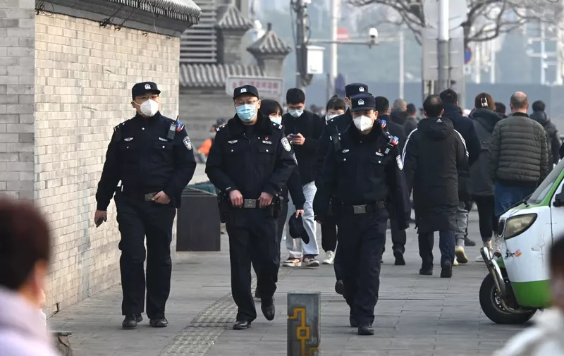 Police officers patrol south of the Great Hall of the People before the opening session of the National Peoples Congress in Beijing on March 5, 2023. (Photo by GREG BAKER / AFP)