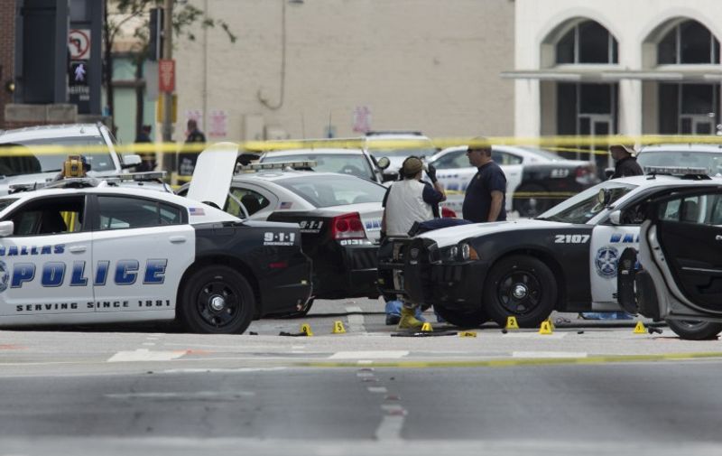 FBI agents examine the crime scene of the Dallas, Texas, sniper shooting on July 9, 2016.
The e gunman behind a sniper-style attack in Dallas was an Army veteran and loner driven to exact revenge on white officers after the recent deaths of two black men at the hands of police, authorities have said. Micah Johnson, 25, had no criminal history, Dallas police said in a statement.
 / AFP PHOTO / Laura Buckman