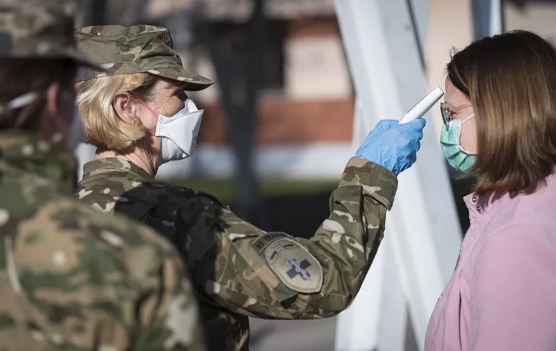 Members of Medical Unit of Slovenian Army measure body temperature prior entering the facilities for treatment of coronavirus patients set at the Edvard Peperko Army Barracks in Ljubljana on March 17, 2020, as many countries around the world go into lockdown in an attempt to stem the spread of  the novel virus COVID-19. (Photo by Jure Makovec / AFP)