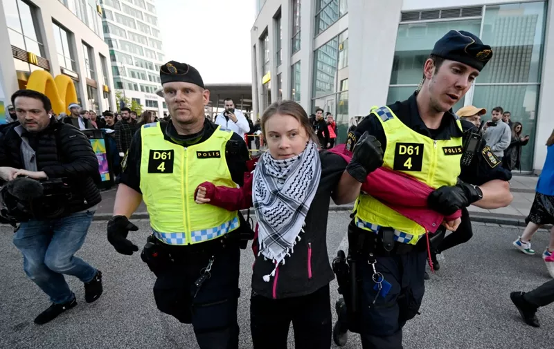 Swedish climate activist Greta Thunberg (C) wearing the keffiyeh scarf is removed by police during a pro-Palestinian demonstration outside the Malmo Arena venue ahead of the final of the 68th Eurovision Song Contest (ESC) 2024 on May 11, 2024 in Malmo, Sweden. (Photo by Johan Nilsson/TT / TT NEWS AGENCY / AFP) / Sweden OUT