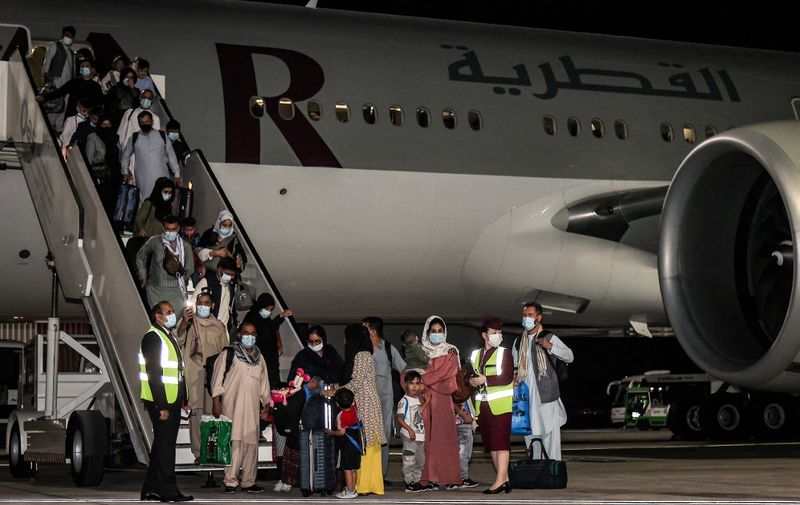 Evacuees from Afghanistan, including US citizens, arrive at Hamad International Airport in Qatar's capital Doha on the first flight carrying foreigners out of the Afghan capital since the conclusion of the US withdrawal last month, September 9, 2021. - Around 100 passengers including Americans arrived in Doha after flying from Kabul airport on September 9, the first flight ferrying out foreigners since the US-led chaotic airlift of more than 120,000 people concluded on August 30. (Photo by KARIM JAAFAR / AFP)