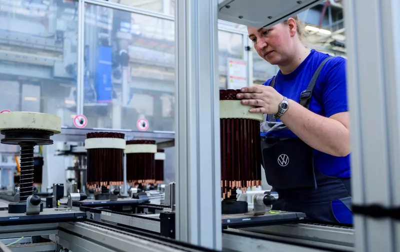 A worker checks a stator, a component for Volkswagen's electric motor found in their ID models, on an assembly line at the VW component plant in Salzgitter, north-central Germany, on May 18, 2022. - A 16 gigawatt hour battery cell factory will be built next to the component plant in 2020, with production to start in late 2023/early 2024 in a 50/50 joint venture with Swedish battery producer Northvolt. (Photo by John MACDOUGALL / AFP)