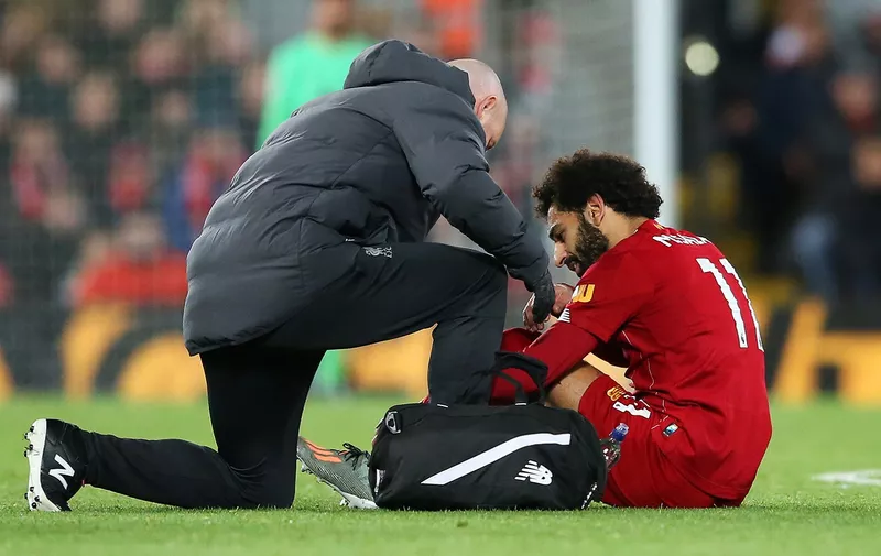 LIVERPOOL, ENGLAND - OCTOBER 27:  An injured Mohamed Salah of Liverpool is given assistance during the Premier League match between Liverpool FC and Tottenham Hotspur at Anfield on October 27, 2019 in Liverpool, United Kingdom. (Photo by Jan Kruger/Getty Images)