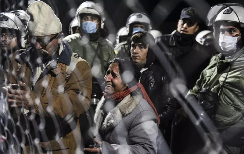 A woman cries as she waits along with other migrants and refugees to cross the Greek-Macedonian border near the town of Gevgelija on December 3, 2015. 
Macedonia has restricted passage to northern Europe to only Syrians, Iraqis and Afghans who are considered war refugees. All other nationalities are deemed economic migrants and told to turn back. Over 1,500 people, mostly Indians, Moroccans, Bangladeshis and Pakistanis, are stuck on the border. / AFP / ARMEND NIMANI
