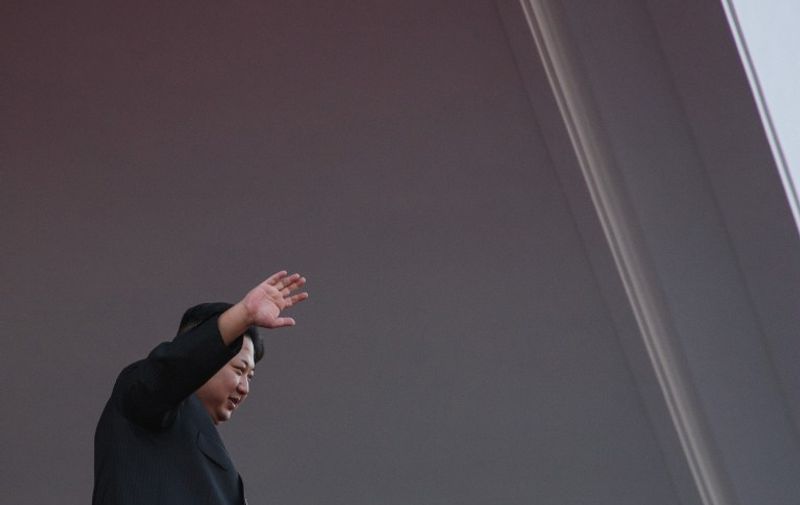 North Korea's leader Kim Jong-Un waves from a balcony towards participants of a mass military parade at Kim Il-Sung square in Pyongyang on October 10, 2015. North Korea was marking the 70th anniversary of its ruling Workers' Party. AFP PHOTO / Ed Jones / AFP PHOTO / ED JONES