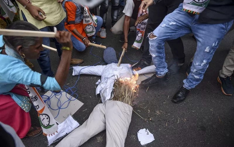 Demonstrators from the National Congress Party (NCP) beat and burn a dummy of a rapist as they protest against rapes in Ranchi, Vadodara, Surat and other regions, following the alleged rape and murder of a 27-year-old veterinary doctor in Hyderabad, in Ahmedabad on December 4, 2019. (Photo by SAM PANTHAKY / AFP)