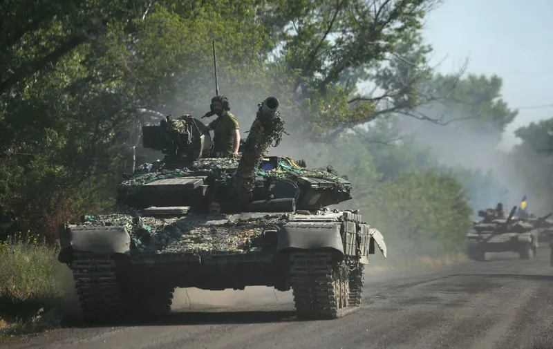 Ukrainian troop move by tanks on a road of the eastern Ukrainian region of Donbas on June 21, 2022, as Ukraine says Russian shelling has caused "catastrophic destruction" in the eastern industrial city of Lysychansk, which lies just across a river from Severodonetsk where Russian and Ukrainian troops have been locked in battle for weeks. Regional governor Sergiy Gaiday says that non-stop shelling of Lysychansk on June 20 destroyed 10 residential blocks and a police station, killing at least one person. (Photo by Anatolii Stepanov / AFP)