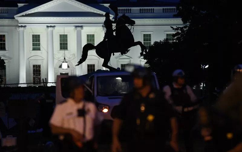 A row of police officers stand guard with the equestrian statue of former US President General Andrew Jackson behind, after protesters tried to topple it, at Lafayette square, in front of the White House, in Washington, DC on June 22, 2020.  A crowd of protestors tried to topple the statue of a former US president near the White House on the evening of June 22 as police responded with pepper spray to break up new demonstrations that erupted in Washington.,Image: 534749088, License: Rights-managed, Restrictions: , Model Release: no