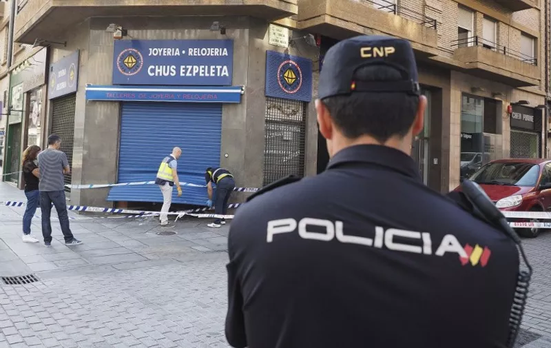 SPAIN, Pamplona: A police officer watches the surroundings of a jewellery shop burgled at dawn in Pamplona, Spain, on July 16, 2015. At least two men forced open the main door and stole golden jewels and high value watches, before leaving in a powerful car, according to police. - CITIZENSIDE/EDUARDO SANZ NIETO