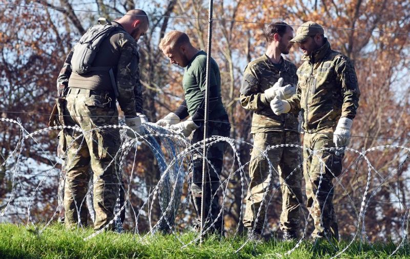 Slovenian soldiers set a barbed wire fence on the Slovenian-Croatian border in Sela pri Dobovi near Brezice, on November 11, 2015. Slovenia on November 10, 2015 outlined plans to build "obstacles", potentially including fences, on its border with fellow EU member Croatia, as it braced for a new spike in migrants bound for northern Europe this week. Prime Minister Miro Cerar, whose country last month found itself on the main Balkans route for thousands of migrants after Hungary sealed its southern borders, insisted however that its frontier would remain open. AFP PHOTO/STRINGER