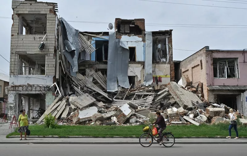 Pedestrians walk past a destroyed store in the city of Okhtyrka, Sumy region on August 1, 2022, amid the Russian invasion of Ukraine. - As towns and villages across Ukraines eastern countryside fell to the swift Russian invasion on February 24, Okhtyrka, a city of 48,000 on the Vorskla River, in Sumy region, resisted occupation. (Photo by Genya SAVILOV / AFP)