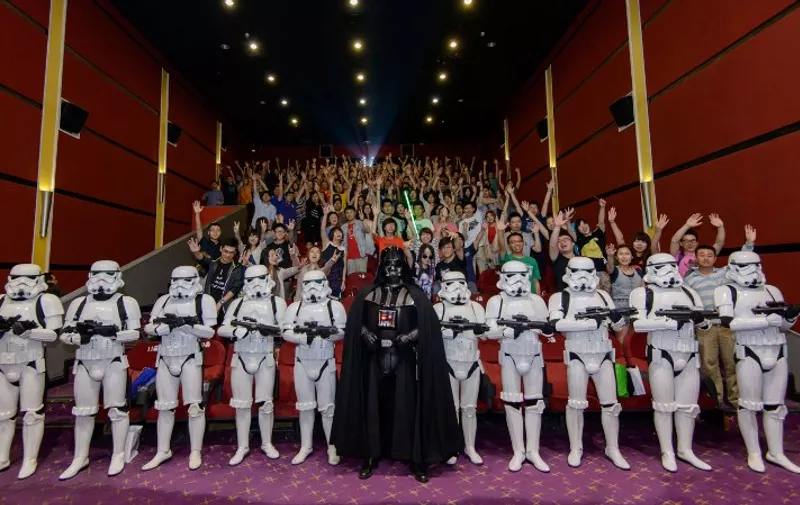 This handout photograph taken on June 14, 2015 and received on June 16, 2015 from Walt Disney Studios China shows Chinese fans (background) posing with Darth Vader (C) and Storm Troopers at a cinema hall in Shanghai. China has become one with the Force by showing the original "Star Wars" film at cinemas for the first time, nearly four decades after it became a global hit and cornerstone of Western popular culture.    AFP PHOTO / WALT DISNEY STUDIOS CHINA
----EDITORS NOTE---- RESTRICTED TO EDITORIAL USE - MANDATORY CREDIT "AFP PHOTO / WALT DISNEY STUDIOS CHINA" - NO MARKETING NO ADVERTISING CAMPAIGNS - DISTRIBUTED AS A SERVICE TO CLIENTS