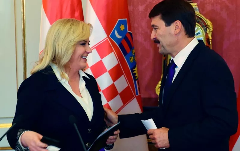 Croatian President Kolinda Grabar-Kitarovic (L) chats with her Hungarian counterpart Janos Ader (R) following a joint press conference in the Marie Theresa Hall of the presidential palace of Buda Castle in Budapest on October 7, 2015. Kolinda Grabar-Kitarovic is on a two-day official visit to Hungary and will meet with her counterparts of Visegrads countries (Czech Republic, Hungary, Poland ans Slovakia). AFP PHOTO / ATTILA KISBENEDEK