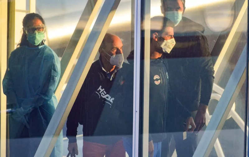 Serbian tennis player Novak Djokovic (R) arrives before heading straight to quarantine for two weeks isolation ahead of their Australian Open warm up matches in Adelaide on January 14, 2021. (Photo by Brenton EDWARDS / AFP)