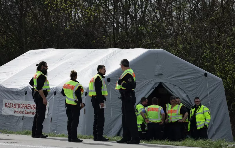 Police officers are seen on the A9 highway, at the scene of a bus accident where at least five people were killed, on March 27, 2024 in Schkeuditz, near Leipzig, eastern Germany. (Photo by Jens Schlueter / AFP)