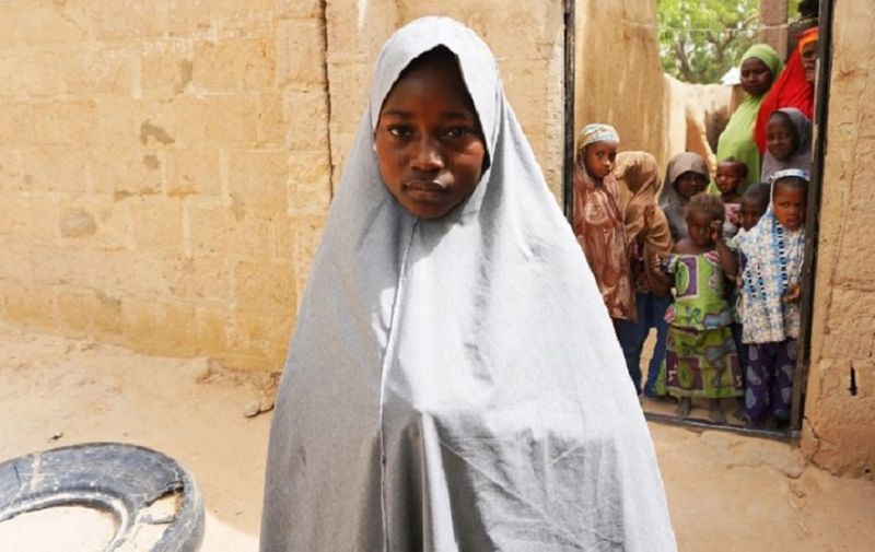 Hassana Mohammed, 13, who scaled a fence to escape an alleged Boko Haram attack on her Government Girls Science and Technical College, stands outside her home in Dapchi, Nigeria, on February 22, 2018.
Anger erupted in a town in remote northeast Nigeria on February 22 after officials fumbled to account for scores of schoolgirls from the college who locals say have been kidnapped by Boko Haram jihadists. Police said on February 21 that 111 girls from the college were unaccounted for following a jihadist raid late on February 19. Hours later, Abdullahi Bego, spokesman for Yobe state governor Ibrahim Gaidam, said "some of the girls" had been rescued by troops "from the terrorists who abducted them". But on a visit to Dapchi on Thursday, Gaidam appeared to question whether there had been any abduction. / AFP PHOTO / AMINU ABUBAKAR
