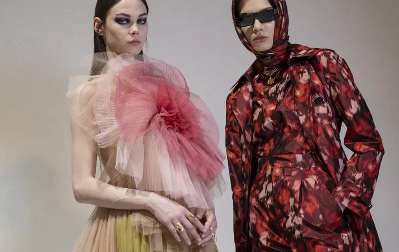 Two models present creations for Christian Dior during the presentation of the Fall/Winter 2021 ready-to-wear fashion collection, on March 6, 2021, in Aubervilliers, on the outskirts of Paris. (Photo by Thomas SAMSON / AFP)