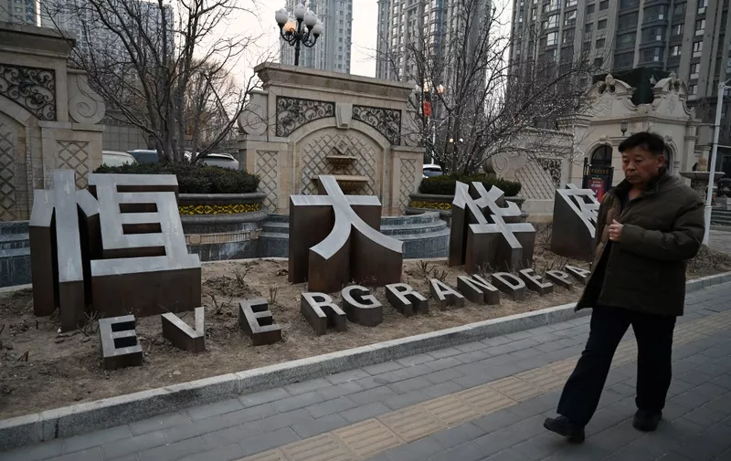 A man walks past an Evergrande Group residential complex called Evergrande Palace in Beijing on January 29, 2024. A Hong Kong court on January 29 ordered the liquidation of China's property giant Evergrande, but the firm said it would continue to operate in a case that has become a symbol of the nation's deepening economic woes. (Photo by GREG BAKER / AFP)