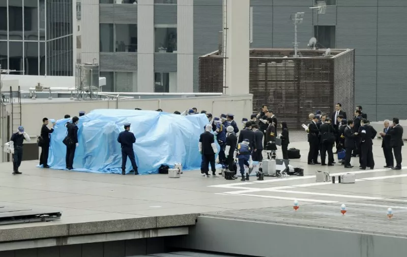 Japanese policemen cover with a blue sheet and inspect a small drone which was found on the roof of the Japanese prime minister&#8217;s official residence in Tokyo on April 22, 2015. Staff at the official residence discovered the 50-centimetre (20-inch) craft on top of the five-story structure in central Tokyo around mid-morning. AFP PHOTO / [&hellip;]