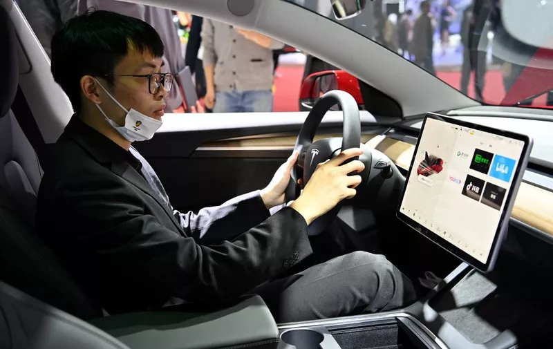 A man is seen inside of a Tesla car during the 19th Shanghai International Automobile Industry Exhibition in Shanghai on April 19, 2021. (Photo by Hector RETAMAL / AFP)
