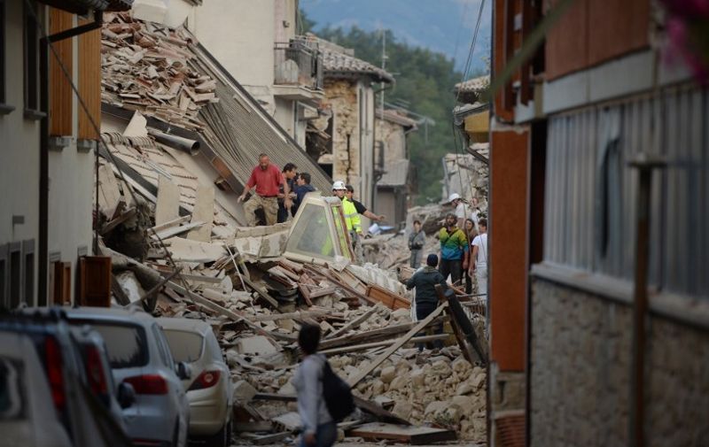 Rescuers and residents search for victim among damaged buildings after a strong heartquake hit Amatrice on August 24, 2016.
Central Italy was struck by a powerful, 6.2-magnitude earthquake in the early hours, which has killed at least three people and devastated dozens of mountain villages. Numerous buildings had collapsed in communities close to the epicenter of the quake near the town of Norcia in the region of Umbria, witnesses told Italian media, with an increase in the death toll highly likely. / AFP PHOTO / FILIPPO MONTEFORTE